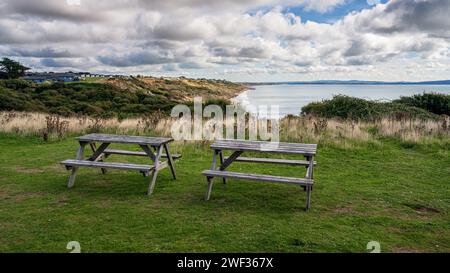 Picknickbänke mit Blick auf die Klippen und Naish Beach in Highcliffe, Dorset, England, Großbritannien Stockfoto