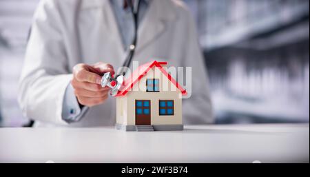 In der Nähe von einem Arzt Hand Stethoskop auf Haus Modell Stockfoto