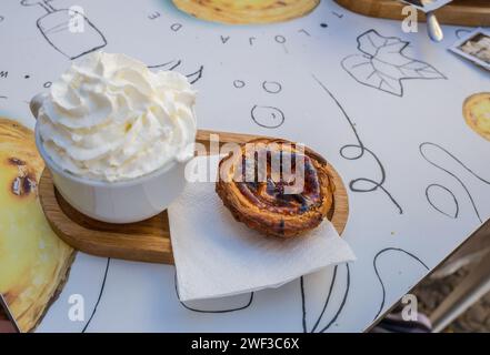 Traditionelle Mareira-Pudding-Tarte serviert mit einem Cappuccino in einem Restaurant in der Hauptstadt Madeiras Funchal. Stockfoto