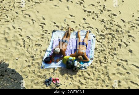 Sonnenbaden auf einer Decke am Strand von Jandia auf Fuerteventura-Süd am 16.01.2018 *** Sonnenbaden auf einer Decke am Strand von Jandia in Fuerteventura Süd am 16 01 2018 Stockfoto