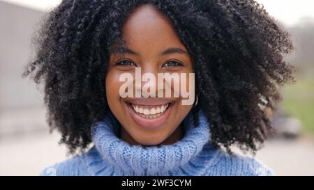 Schöne afrikanische junge Frau, die vor der Kamera lächelt Stockfoto