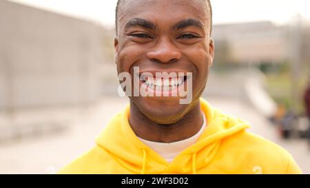 Ein afrikanischer junger Mann steht und lacht Stockfoto