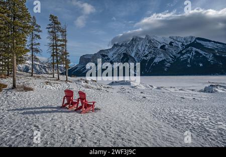 Blick auf die roten Stühle im gefrorenen Lake Minnewanka im Banff National Park, Alberta, Kanada Stockfoto