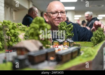 Kendal, Cumbria 28. Januar 2024 - ein Aussteller bastelt an den Zügen. - Junge und alte Zugliebhaber genießen die Modelleisenausstellungen im Kendal Freizeitzentrum in Cumbria. Vor Kurzem hat die Warley National Model Railway Exhibition in Birmingham ihre jährliche Ausstellung wegen einer alternden Mitgliedschaft abgesagt. Die Kinder in Kendal waren alle fasziniert von den Ausstellungen, als die Züge die Strecke umrundeten. Quelle: Stop Press Media/Alamy Live News Stockfoto