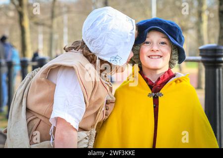 London, UK 28. Januar 2024. (l-t-r) Ein kleiner Kuss für Wilf von Ivy. Die Kinder Ivy, Wilf und Joseph versammeln sich, um an der Prozession teilzunehmen. Jedes Jahr marschieren die Freiwilligen der englischen Bürgerkriegsgesellschaft mit der Kings Army entlang der Mall in London und zur Horse Guards Parade, zum Gedenken an Karl I., der am 30. Januar 1649 zum Märtyrer wurde. Jedes Regiment in der Nachstellung besteht aus Offizieren, Musketen, gefolgt von der Farbe, Trommlern, Pikeniern und Gepäck (Frauen und Kinder). Die Prozession wird vom Generalleutnant der Königsarmee und den Reitern geführt. Stockfoto