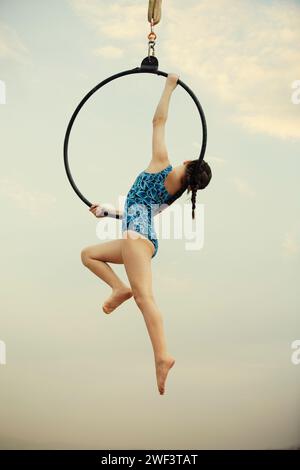 12 Jahre alte Turnerin, die draußen auf einem Luftkorb auftritt Stockfoto