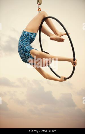 12 Jahre alte Turnerin, die draußen auf einem Luftkorb auftritt Stockfoto