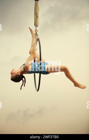 12 Jahre alte Turnerin, die draußen auf einem Luftkorb auftritt Stockfoto