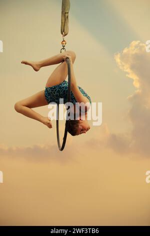 12 Jahre alte Turnerin, die draußen auf einem Luftkorb auftritt Stockfoto