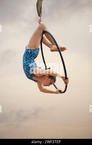 12 Jahre alte Turnerin, die draußen auf einem Luftkorb auftritt Stockfoto