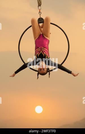 12 Jahre alte Turnerin, die draußen auf einem Luftkorb auftritt Stockfoto