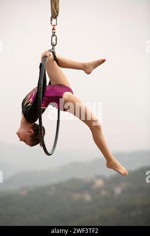 12 Jahre alte Turnerin, die draußen auf einem Luftkorb auftritt Stockfoto