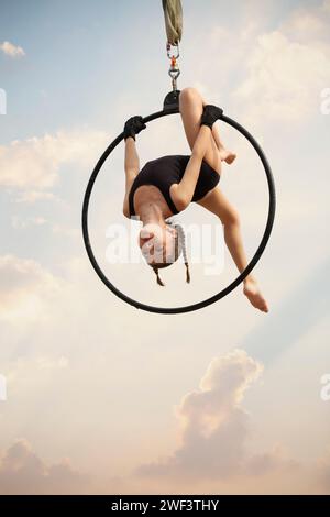 12 Jahre alte Turnerin, die draußen auf einem Luftkorb auftritt Stockfoto