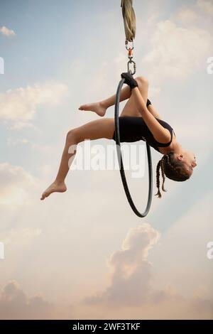 12 Jahre alte Turnerin, die draußen auf einem Luftkorb auftritt Stockfoto