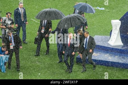 Moskau, Russland – 15. Juli 2018. Der russische Präsident Wladimir Putin begleitete im strömenden Regen nach der Siegerehrung des Wo vom Platz Stockfoto