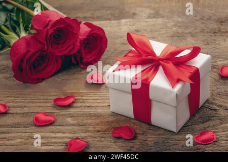 Valentinstag Grußkarte Hintergrund mit Geschenkbox, frischen burgunderroten Rosen und verschiedenen Herzen. Stockfoto