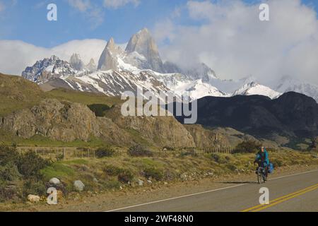 Ein Radfahrer fährt auf einer Straße vor dem Cerro Fitzroy in der Nähe von El Chalten in Argentinien. Stockfoto