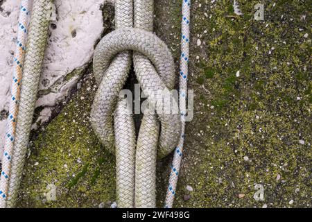 Der Riffknoten oder Quadratischer Knoten. Seilknoten eines großen Fischereifahrzeugs im Hafen von Grado. Ausrüstung für die Fischereiindustrie. Wird von Seeleuten verwendet. Stockfoto