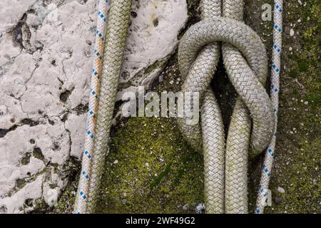 Der Riffknoten oder Quadratischer Knoten. Seilknoten eines großen Fischereifahrzeugs im Hafen von Grado. Ausrüstung für die Fischereiindustrie. Wird von Seeleuten verwendet. Stockfoto