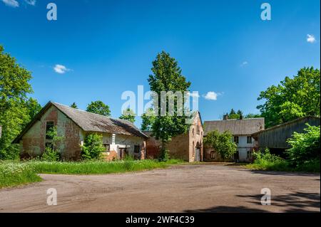 Backsteingebäude und hölzerne Nebengebäude, Überreste eines zerstörten Anwesens. Manor Aumeisteri, Lettland. Stockfoto