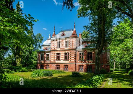 Das Herrenhaus Aumeisteru wurde im neogotischen Stil erbaut. Blick auf das Anwesen gegenüber des Parks. Lettland, Baltikum. Stockfoto