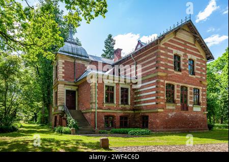 Das Herrenhaus Aumeisteru wurde im neogotischen Stil erbaut. Blick auf den Hinterhof. Lettland, Baltikum. Stockfoto