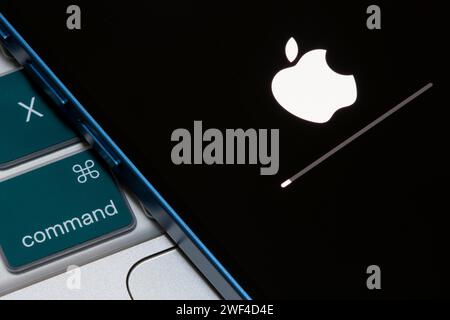 Nahaufnahme des Apple-Logos und der Fortschrittsleiste, die auf einem iPhone angezeigt werden, wenn die iOS-Firmware auf die neueste Version aktualisiert wird. Stockfoto