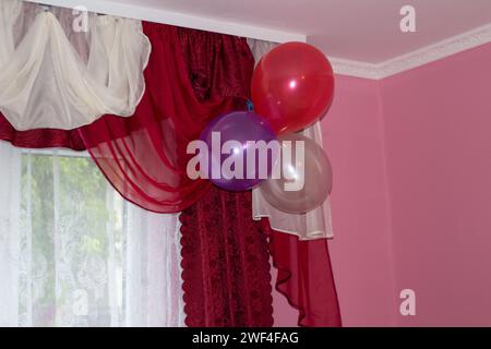 Vorhänge sind mit Luftballons im Zimmer dekoriert Stockfoto