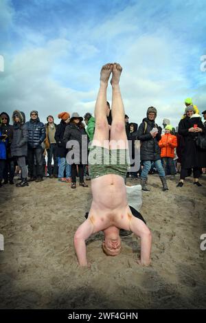 Nach dem Polar Bear Club Neujahrsschwimmen 2016 steht ein Teilnehmer auf seinem Kopf. In Coney, Island, Brooklyn, New York. Stockfoto