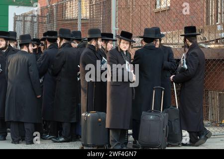 Eine Gruppe von eng gepackten orthodoxen jüdischen Männern wartet auf einen Bus, um sie zu den Klassen auf der anderen Seite von Brooklyn zu bringen. In Williamsburg. Stockfoto