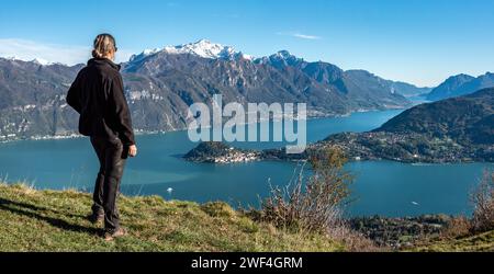 Ein Wanderer, der die herrliche Aussicht auf Bellagio am Comer See vom Monte Crocione, Italien, genießt Stockfoto