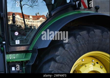 Magdeburg, Deutschland. Januar 2024. Der Bau des landtags Sachsen-Anhalt spiegelt sich in einer Traktorscheibe bei der Bauernkundgebung auf dem Domplatz wider. Unter dem Motto "zu viel ist zu viel" protestierten Hunderte von Bauern und Forstwirten aus mehreren bundesländern gegen die Haushaltspolitik der Bundesregierung. Quelle: Heiko Rebsch/dpa/Alamy Live News Stockfoto