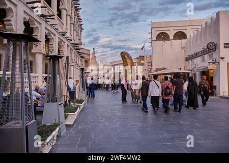 Souk Waqif Doha, Blick auf die Hauptstraße Katars bei Tageslicht mit dem Daumendenkmal und dem islamischen Kulturzentrum Katars (FANAR) im Hintergrund Stockfoto