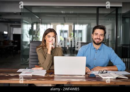 Glückliche Geschäftsleute sitzen mit Laptop im Büro. Hochformat Stockfoto