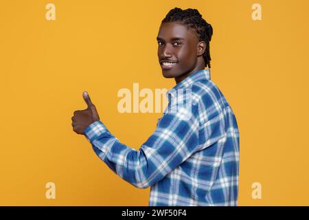 Der Lächelnde Junge Schwarze Zeigt Den Daumen Hoch In Die Kamera Stockfoto