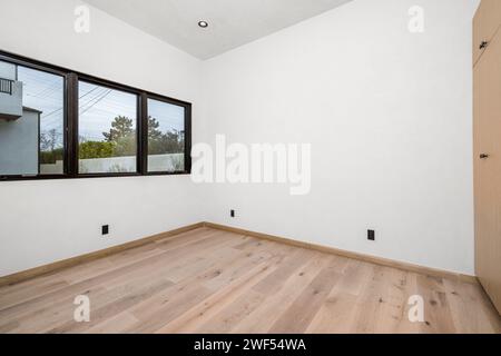 Leeres weißes Zimmer mit Holzfußboden und Fenster Stockfoto