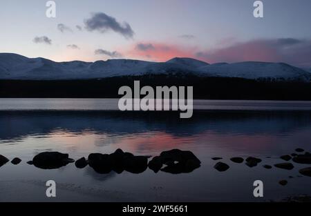 Ein abendlicher Blick auf Loch Morlich und die Cairngorm Mountains im Winter, Cairngorm National Park. Stockfoto