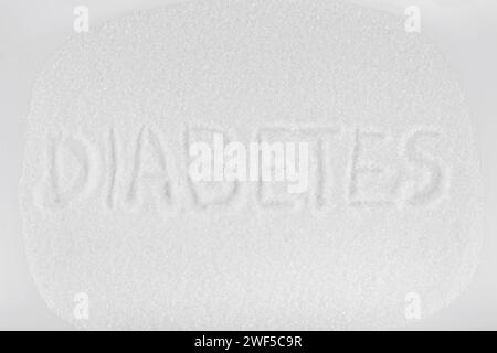 Weißer Kristallzucker und Phrase Diabetes auf weißem Hintergrund Stockfoto