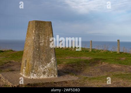 Sheringham, Norfolk, Großbritannien – 27. Januar 2024. Betonmarkierungspunkt auf dem Gipfel des Beeston Hill auf dem North Norfolk Coastal Path Stockfoto