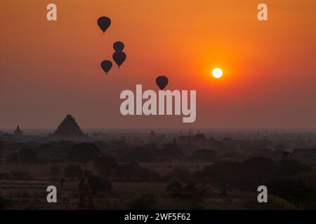 Malerische Landschaft mit vielen antiken Tempeln und Pagoden und Heißluftballons über der Ebene von Bagan in Myanmar (Burma) bei Sonnenaufgang. Stockfoto