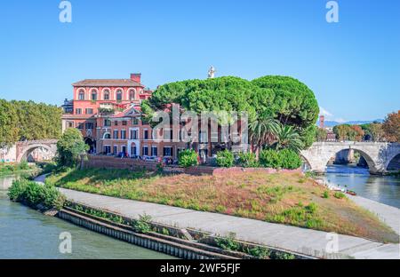 Tiberinsel in Rom, Italien mit dem Krankenhaus Fatebenefratelli und Ponte Cestio auf der rechten Seite, einer antiken römischen Steinbrücke. Stockfoto