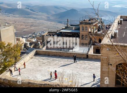 Schulkinder spielen Fußball auf dem Dach in der historischen Stadt Mardin im Südosten der Türkei Stockfoto