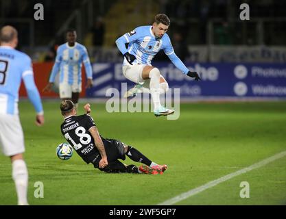 München, Deutschland 28. Januar 2024: Fussball, Herren, 3.Liga, Saison 2023/2024, TSV 1860 München - SV Sandhausen, Grünwalder Stadion Julian Guttau (TSV 1860 München) (oben) springt über Dennis Diekmeier (SV Sandhausen) (am Boden), Zweikampf um den Ball DFB-Vorschriften verbieten jede Verwendung von Fotografien als Bildsequenzen und/oder Quasi-Video Stockfoto