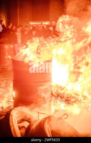 Turnhout, Antwerpen, Belgien, 28. Januar 2024, dieses Foto fängt einen intensiven Moment des Protests der Bauern von Turnhout gegen das Stickstoffabkommen in Belgien ein, wobei der Schwerpunkt auf einem Lagerfeuer liegt, das in einem Fass brennt. Die Flammen springen energisch und strahlen ein warmes Leuchten aus, das die Gesichter der Zuschauer beleuchtet, die mit einer Mischung aus Besorgnis und Entschlossenheit zusehen. Das Feuer wird zum zentralen Symbol des Protestes, zum Leuchtfeuer für die feurige Entschlossenheit der Bauern gegen die umstrittene Politik. Die Menge im Hintergrund ist teilweise verschwommen, was die Sichtbarkeit des Feuers im Schuss unterstreicht. Flammen der Trotz: Stockfoto