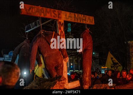 Turnhout, Antwerpen, Belgien, 28. Januar 2024, dieses Bild ist eine Nahaufnahme der turbulenten Flamme des Protests der Landwirte in Turnhout, Belgien, gegen das Stickstoffabkommen. Das Feuer dominiert den Rahmen, mit seinen wilden Zungen aus Flammen, die in einem Tanz des Trotzes ausbreiten und ein fast abstraktes Muster aus Licht und Energie erzeugen. Der intensive orange Farbton sättigt die Szene, unterbrochen von der Straßenlaterne, die durch den rauchigen Dunst im Hintergrund dringt, was auf die urbane Umgebung des Protestes hindeutet. Die Kopfsteinpflasterstraße unter den Flammen deutet auf die historische und traditionelle Kulisse hin Stockfoto