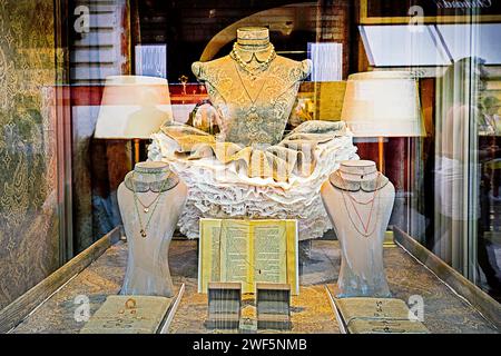 Weibliche Schaufensterpuppe in einem teuren Brokatkleid mit Golddekorationen in einem Vintage-Interieur Stockfoto