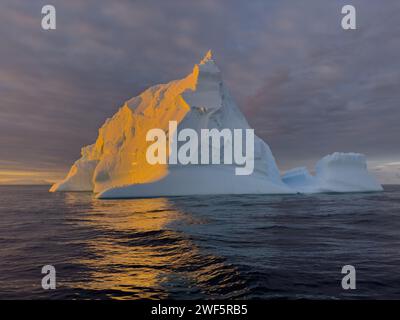 Ein riesiger hoher, abbrechender Gletscher driftet im südlichen Ozean vor der Küste der Antarktis bei Sonnenuntergang, der Antarktischen Halbinsel, dem südlichen Polarkreis Stockfoto