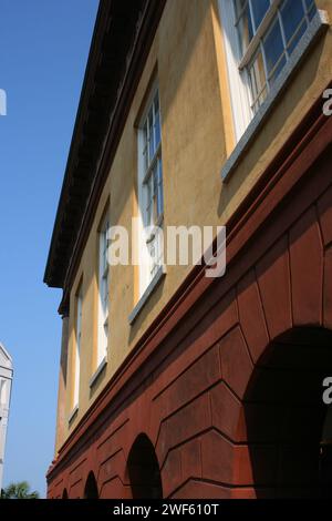 Ein warmer Blick auf ein klassisches europäisches Gebäude mit bogenförmigem Durchgang am Sommernachmittag Stockfoto