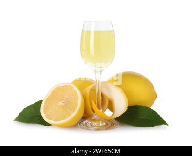 Likörglas mit leckerem Limoncello, Zitronen und grünen Blättern isoliert auf weiß Stockfoto