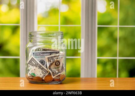 Münzgefäß mit Bargeld und Münzen. Konzept für Altersvorsorge, Spareinlagen und Finanzplanung. Stockfoto
